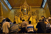 Applying gold leaf to statue at Mahamuni Pagoda, Myanmar 